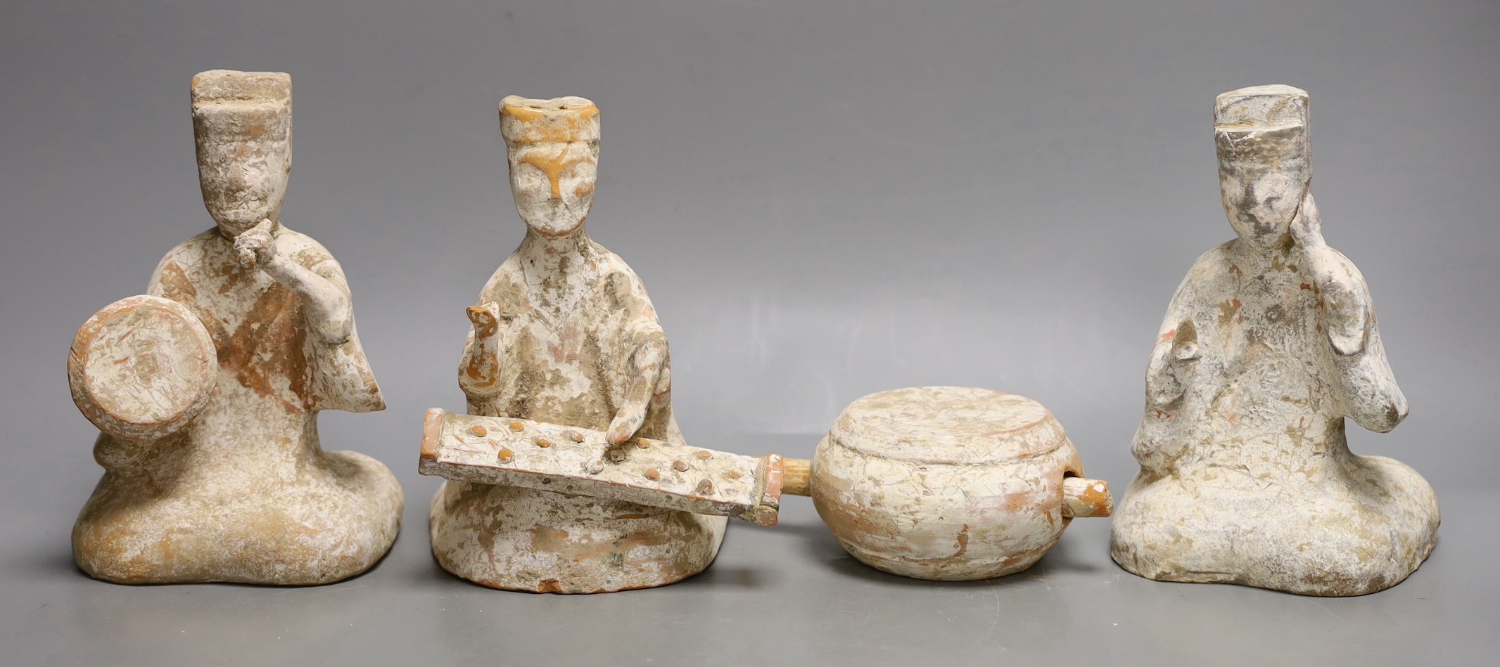 Three Chinese painted pottery figures of musicians and a model drum, Tang dynasty or later, 18.5cms high